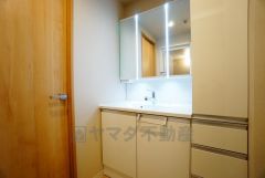 三面鏡つき洗面台。鏡裏にたっぷりとした収納スペースがあります。鏡を閉めてしまえば小物は見えないため、スッキリとした印象の洗面台にできます。