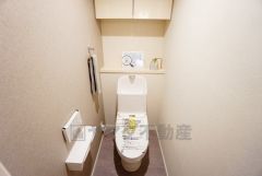 壁リモコンタイプのウォシュレット付き。すっきりした見た目で、トイレ奥の掃除もしやすいです。棚やタオル掛けも設けています。