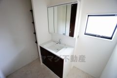 三面鏡つき洗面台。鏡裏にたっぷりとした収納スペースがあります。鏡を閉めてしまえば小物は見えないため、スッキリとした印象の洗面台にできます。