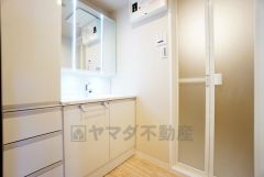 三面鏡つき洗面台。鏡裏にたっぷりとした収納スペースがあります。鏡を閉めてしまえば小物は見えないため、スッキリとした印象の洗面台にできます。