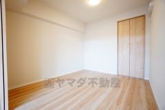 リビング隣の洋室です。木目調のシンプルデザインで落ち着きと安らぎの空間に仕上げています。各部屋に収納が完備されているので、お荷物が増えても安心の設計です。