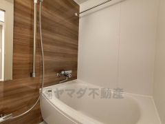 木目調パネルが上質な雰囲気を演出するバスルームは、一日の疲れをゆったり癒せるくつろぎ空間。浴室上部には洗濯物を掛けられる物干し竿が設置されています。