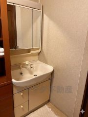 三面鏡つき洗面台。鏡裏にたっぷりとした収納スペースがあります。鏡を閉めてしまえば小物は見えないため、スッキリとした印象の洗面台にできます。