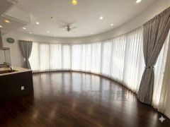 大きな曲線の窓からたっぷりの自然光が差し込む、開放感あふれるリビング空間。