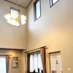 吹抜けの開放感とともに、大きな窓からたっぷりの自然光が差し込む明るいリビング空間。心地よい陽だまりが広がり、家族でゆったり過ごせる上質なひとときを演出します。