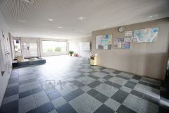 落ち着いた雰囲気の広々としたロビーが開放感を演出しています。掲示板には最新の情報が共有されています。