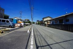 現地（2025年6月27日）撮影。2.3号棟前面道路。前面道路幅員10メートルで車が停めやすい環境。日当たり、風通し良好です。