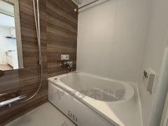 木目調アクセントパネルが落ち着いた雰囲気を演出するバスルーム。ゆったりとした浴槽で一日の疲れを癒せるほか、手元操作のしやすい水栓や清掃性に配慮した設計で、毎日のバスタイムを快適にサポートします。