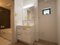 三面鏡つき洗面台。鏡裏にたっぷりとした収納スペースがあります。鏡を閉めてしまえば小物は見えないため、スッキリとした印象の洗面台にできます。