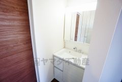 三面鏡つき洗面台。鏡裏にたっぷりとした収納スペースがあります。鏡を閉めてしまえば小物は見えないため、スッキリとした印象の洗面台にできます。