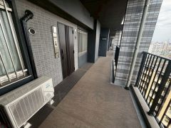 落ち着いたデザインの玄関アプローチ。共用廊下はゆとりのある造りで開放感があり、通風や採光にも配慮された快適な住環境です。高層階ならではの景色も感じられる、気持ちの良い玄関まわりです。