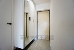 白を基調とした清潔感のある玄関。お出かけ前に全身鏡でコーディネートをチェックできますね。