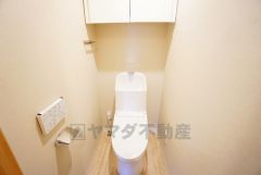 壁リモコンタイプのウォシュレット付き。すっきりした見た目で、トイレ奥の掃除もしやすいです。また棚も設けています。