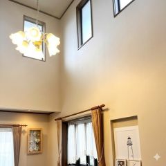 吹抜けの開放感とともに、大きな窓からたっぷりの自然光が差し込む明るいリビング空間。心地よい陽だまりが広がり、家族でゆったり過ごせる上質なひとときを演出します。
